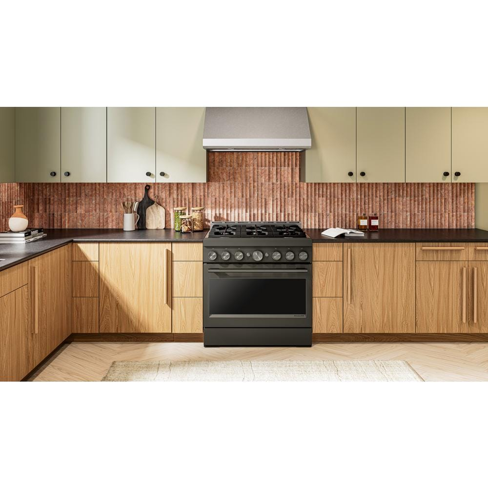 Dark commercial-style gas range with six burners and metal control knobs in modern kitchen setting with wood cabinets
