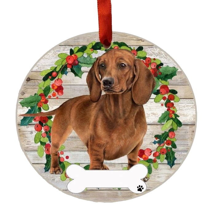 Round Christmas ornament with a red dachshund in front of a festive holly wreath and a blank bone-shaped name tag