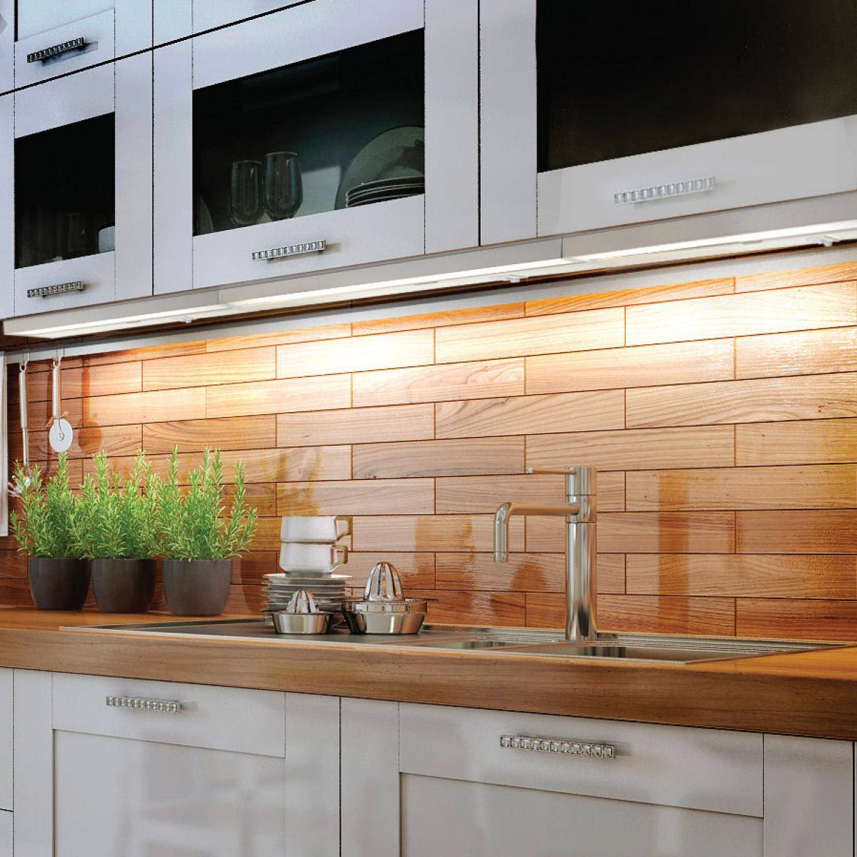 Under-cabinet white LED light illuminating kitchen countertop with stainless steel sink and wood backsplash paneling