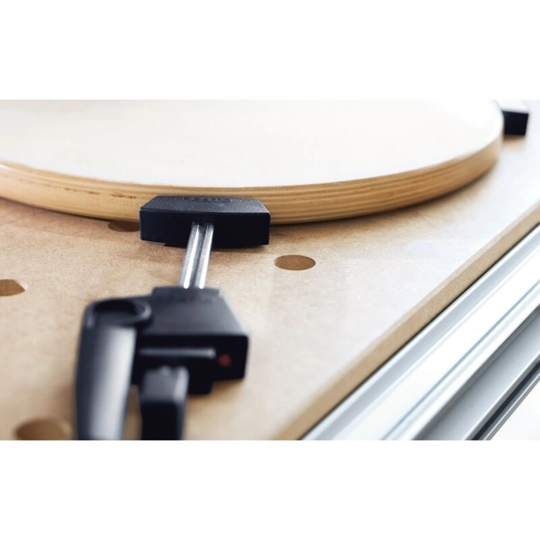 Cam-action clamping element holding round wooden piece on perforated board for woodworking tools and accessories