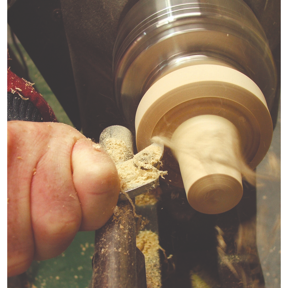 Handheld cutting tool shaping wood on lathe with fine shavings for woodworking tools and home improvement collections