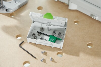 Open Festool Systainer storing routing accessory components including guide rail adapters and screws for woodworking tools