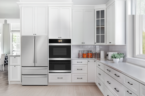 Built-in stainless steel smart combination wall oven and microwave drawer integrated into white cabinetry in modern kitchen
