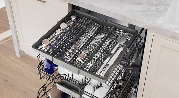 Open 24-inch custom panel ready dishwasher drawer loaded with neatly organized silverware in modern kitchen setting