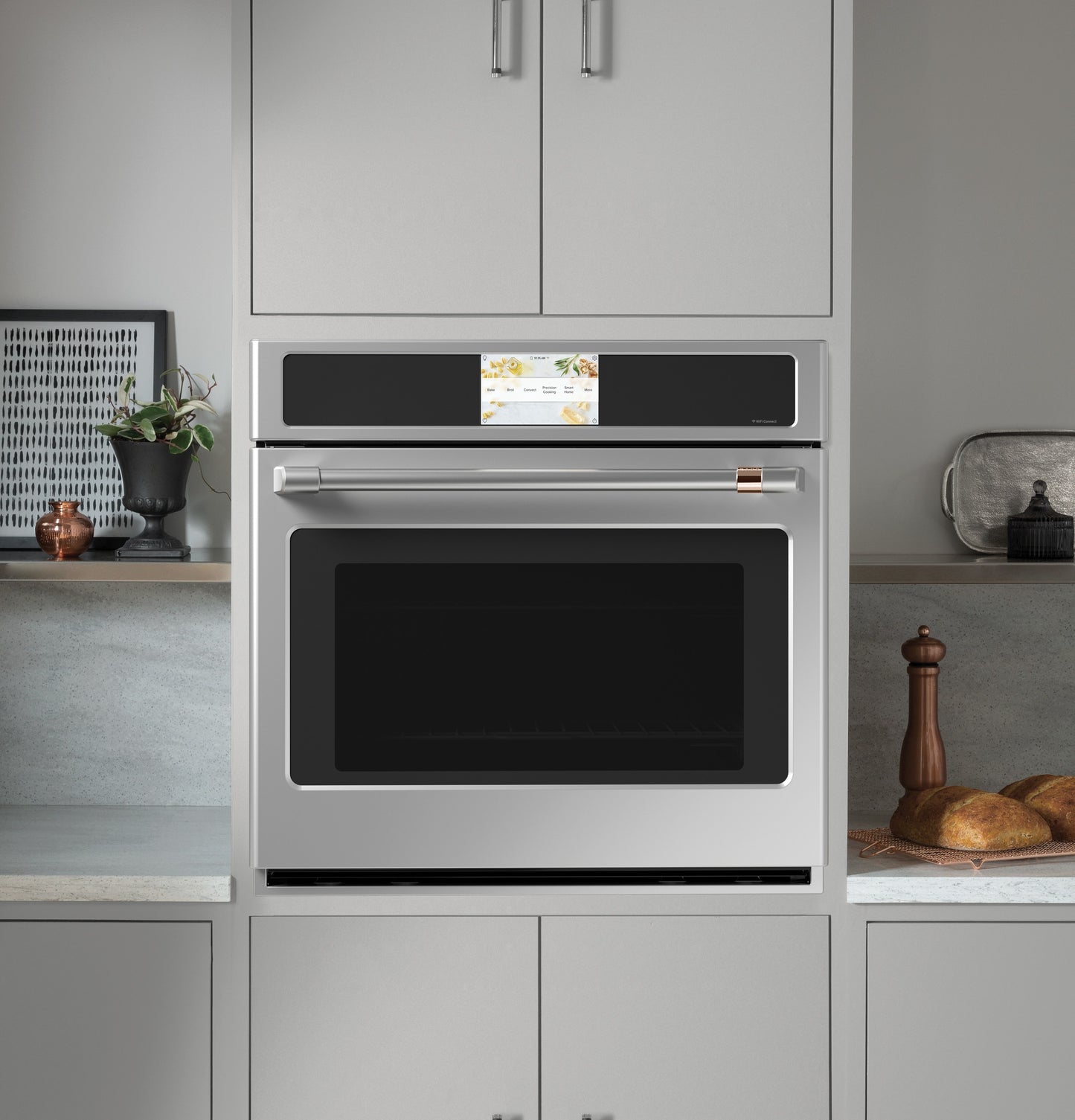 Built-in stainless steel single wall oven with digital touchscreen and modern kitchen cabinetry surrounding it