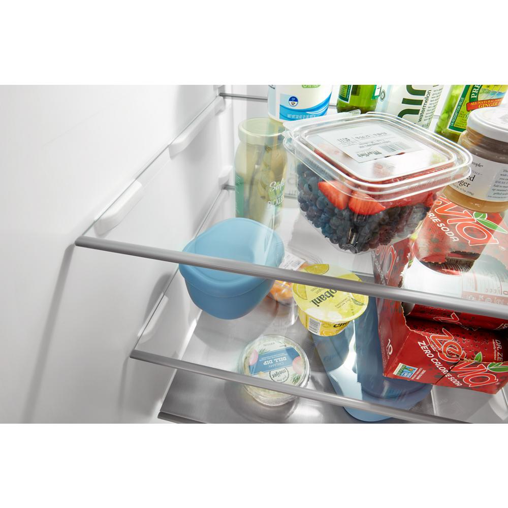Inside view of side-by-side refrigerator with framed glass shelves organizing drinks, berries, and packaged food in Appliances collection
