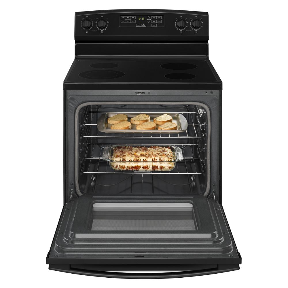 Electric range with glass cooktop and open oven door showing toasted bread and baked casserole inside oven cavity.