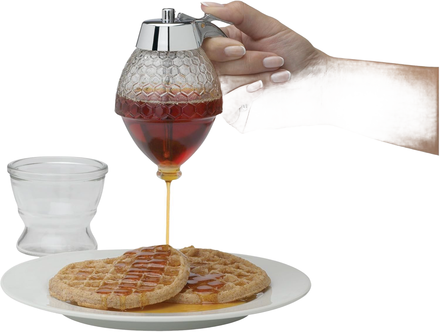 Glass honeycomb-patterned syrup dispenser with chrome lid pouring syrup on waffles in kitchenware and food storage collection