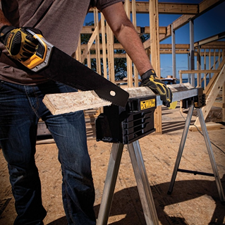 Metal folding sawhorse with aluminum legs and black plastic top supports used in outdoor construction site tasks