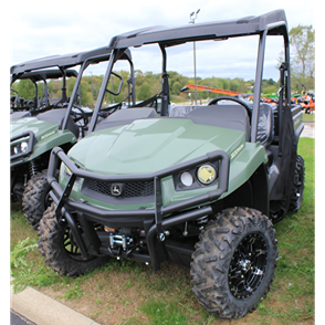 Green mid-size utility vehicle with front brush guard and large off-road tires for outdoor use