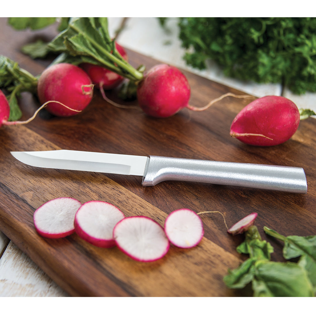 Sharp paring knife with cast aluminum handle slicing fresh radishes on wooden board in Kitchenware collections under $50