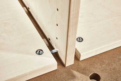 Wood panel joint secured with metal center panel connectors for stable knock-down joinery in woodworking tool accessories collection