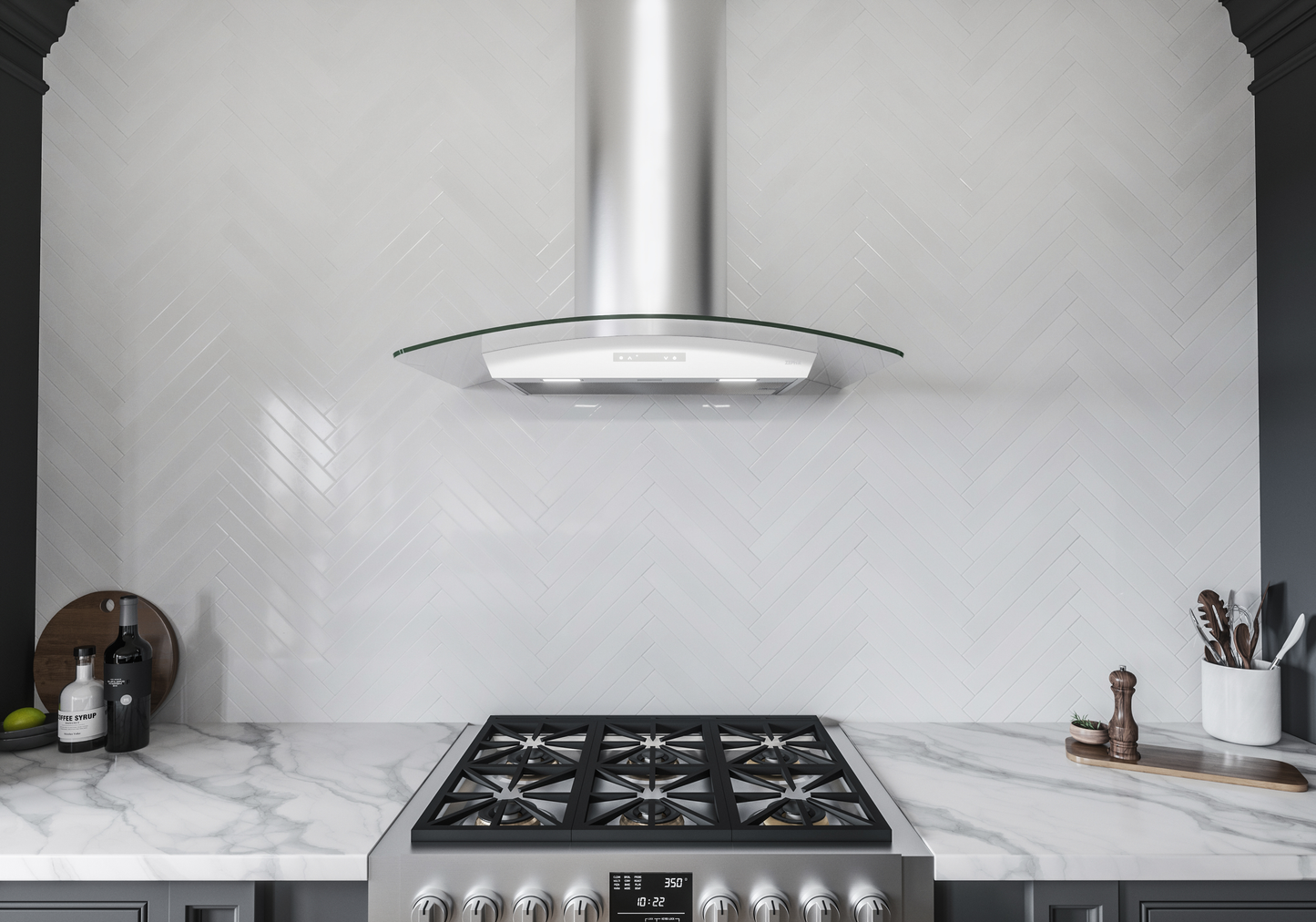Curved glass canopy chimney hood in stainless steel with LED lights above stainless steel gas range in kitchen collection