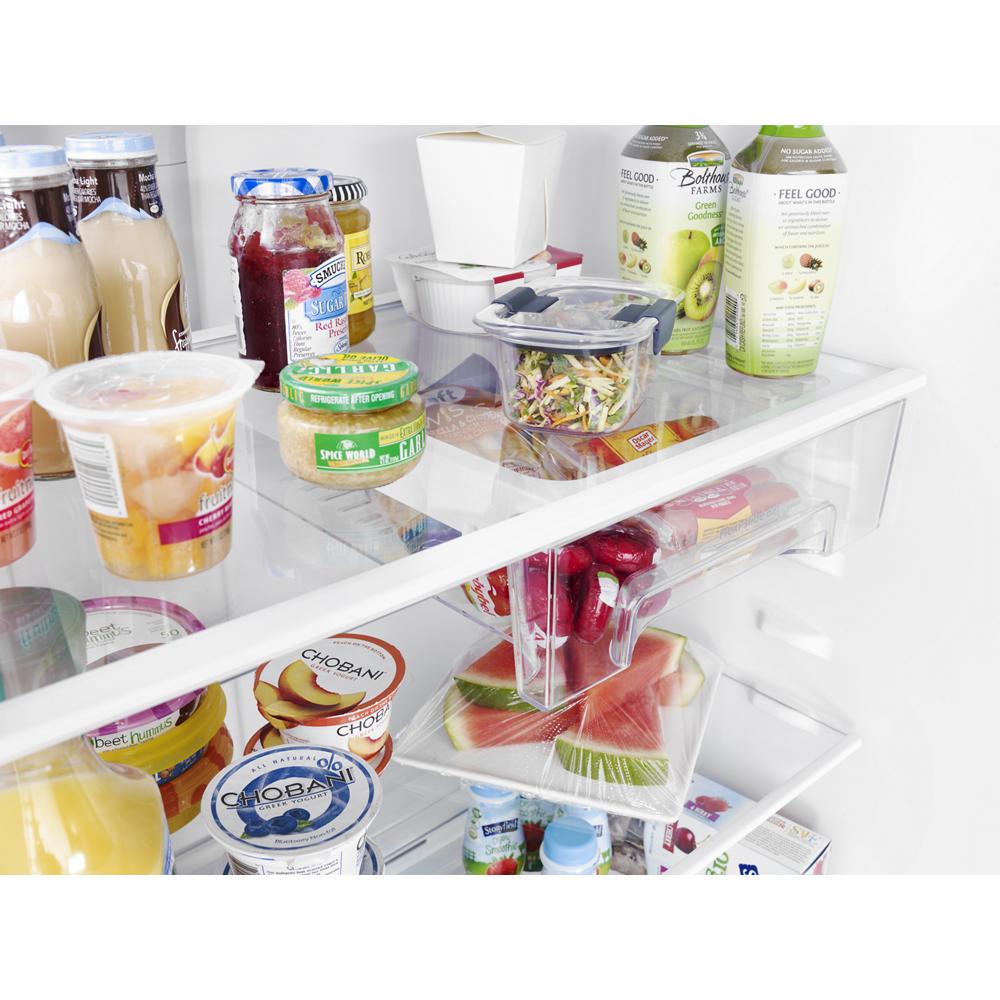 Interior view of a top freezer refrigerator showing organized shelves with beverages, yogurt, and fresh produce storage bins