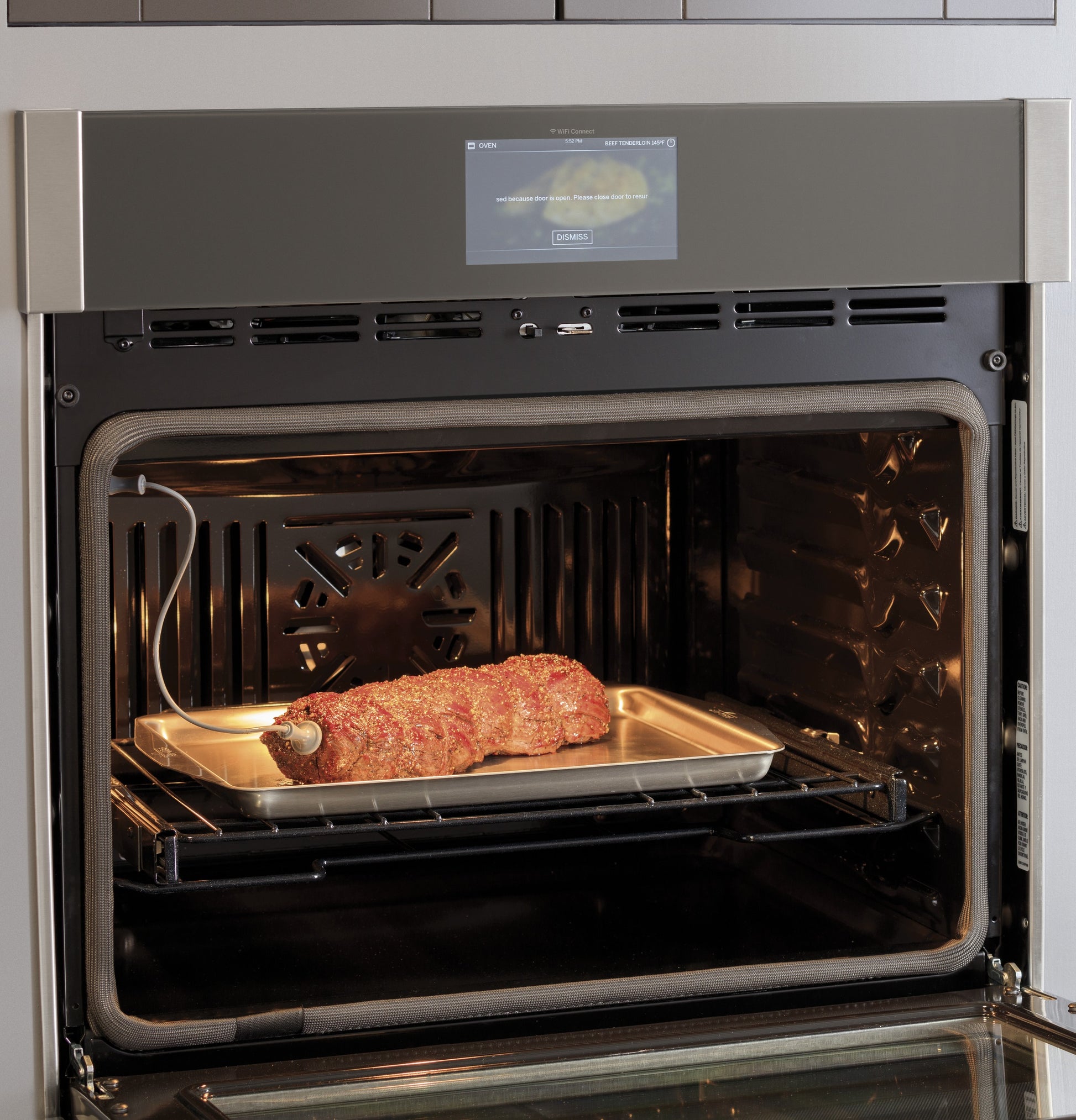 Roast cooking inside open stainless steel convection double wall oven with digital touchscreen in kitchen appliance setting