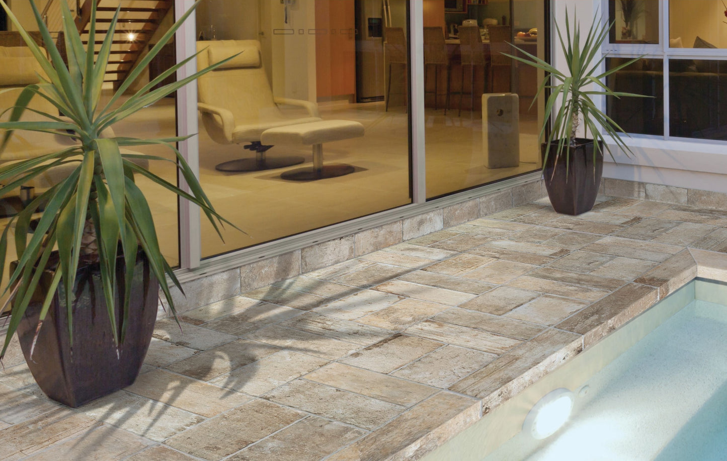 Matte porcelain tile in neutral shades with varied rectangular layout on outdoor patio by pool for home improvement