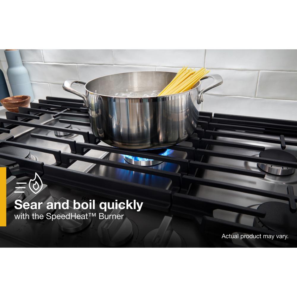 36-inch gas cooktop with five burners and hinged cast-iron grates heating a pot of boiling water in kitchen setting