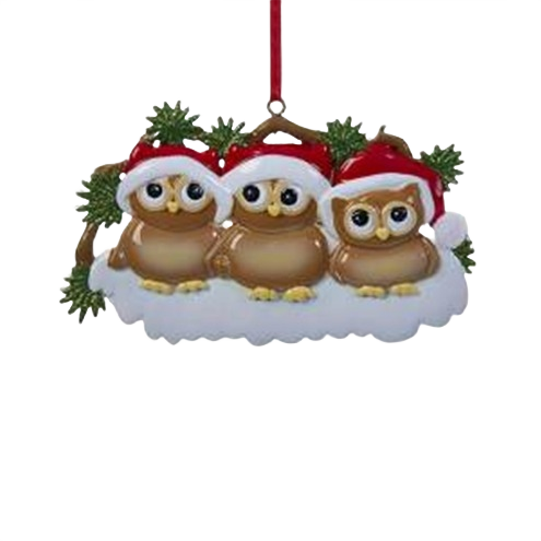 Three brown owls wearing red Santa hats resting on snow with green pine accents Christmas ornament decor