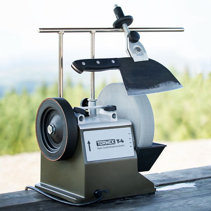 Knife secured on an extended universal support with micro adjust on a Tormek water-cooled sharpening machine outdoors