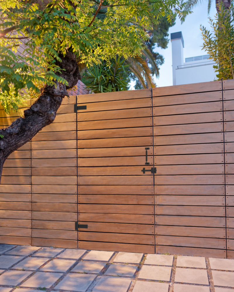 Black industrial gate hardware set with latch and hinges on modern wooden gate in home improvement collection