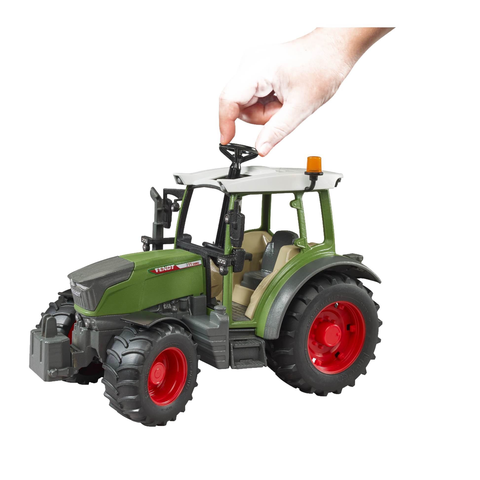 Child’s hand adjusting the steering wheel of a green and red Bruder Fendt Vario 211 Tractor toy from Vehicles & Remote Controlled Toys collection