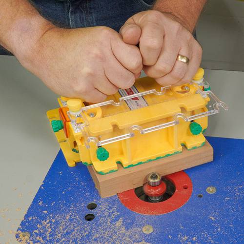 Yellow and green woodworking push block clamped on wood for enhanced safety in saw and power tool accessories collection