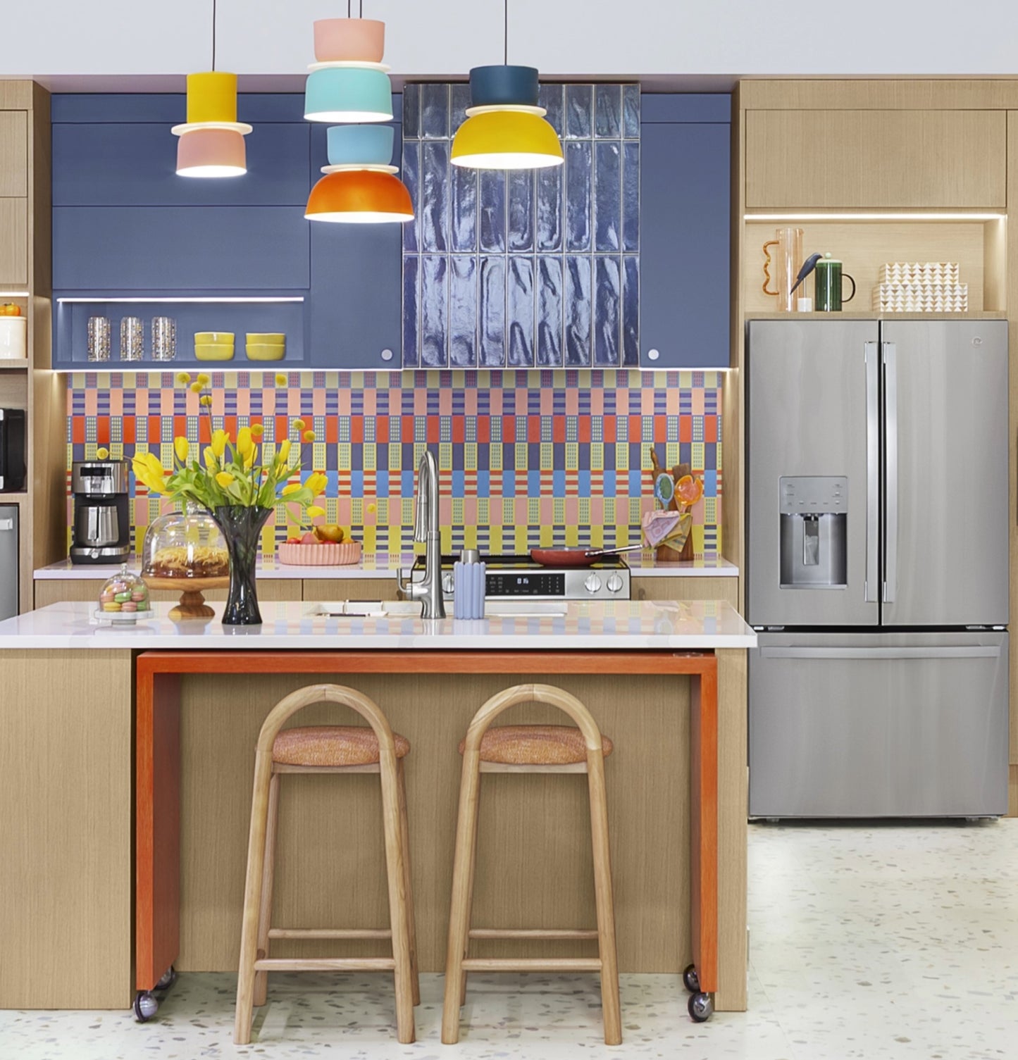 Modern kitchen with fingerprint resistant French-door refrigerator, colorful tile backsplash, and wooden island with stools in appliances collection