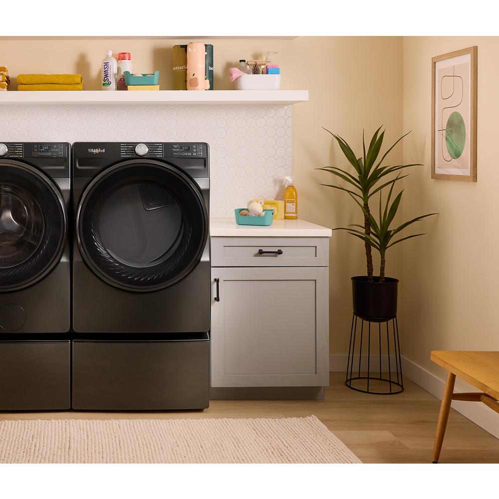 Matte black smart front load electric dryer and washer set in a modern laundry room with storage and plant nearby