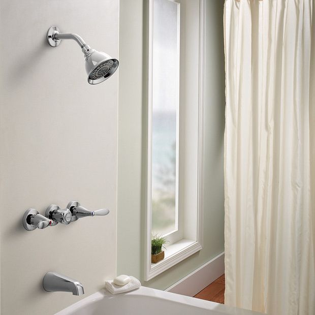 Chrome three-handle tub and shower trim with attached showerhead in bathroom setting featuring window and shower curtain