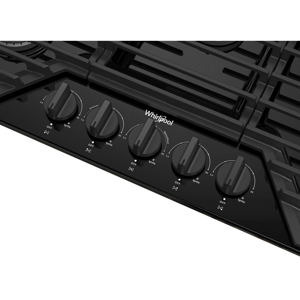 Close-up of black control knobs on a sleek gas cooktop with EZ-2-Lift™ hinged cast-iron grates in kitchen appliances collection