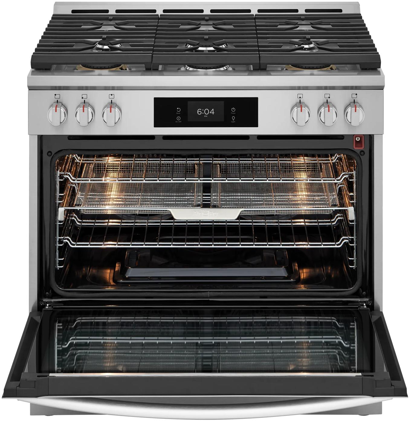 Stainless steel gas range with six burners and open oven door featuring multiple racks and digital display panel