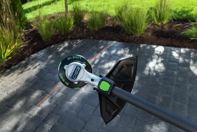Cordless string trimmer head with Line IQ™ system, green and black design, used for home improvement gardening tasks