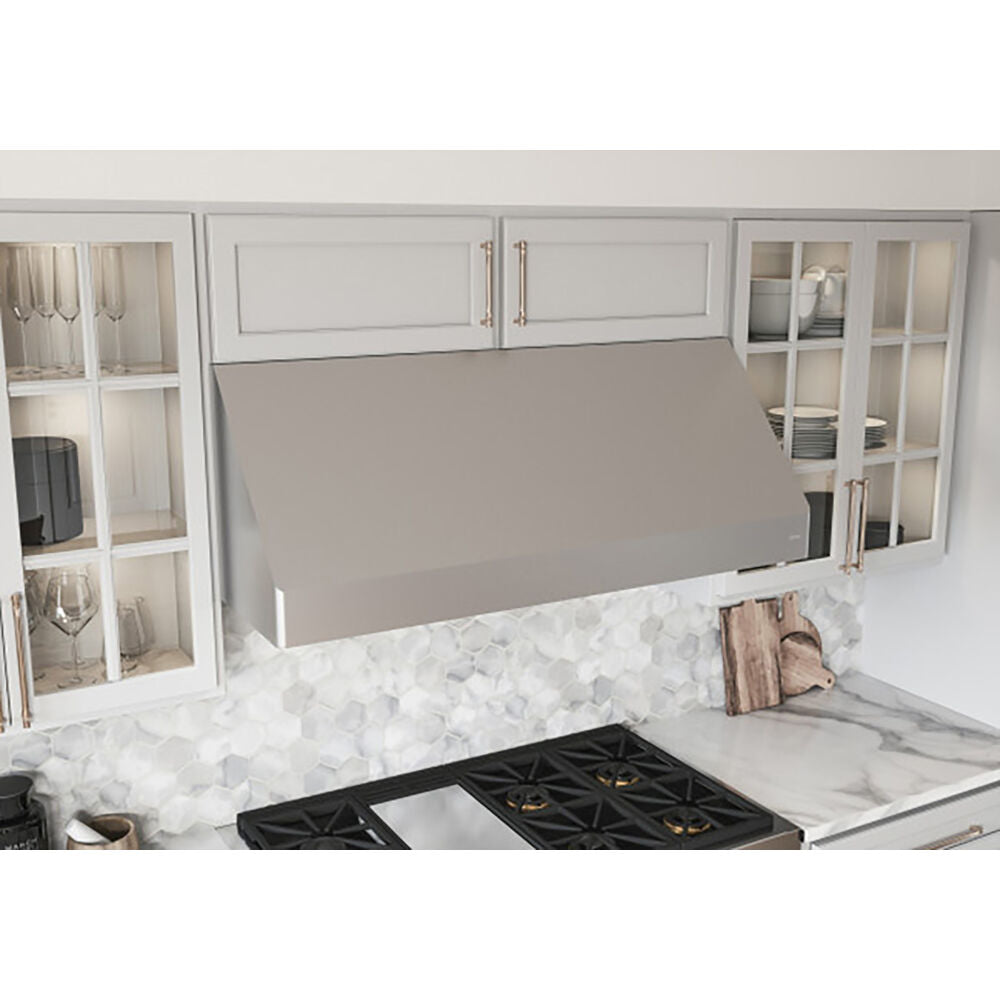Brushed stainless steel canopy hood over black gas cooktop in kitchen with white cabinetry and hexagonal tile backsplash