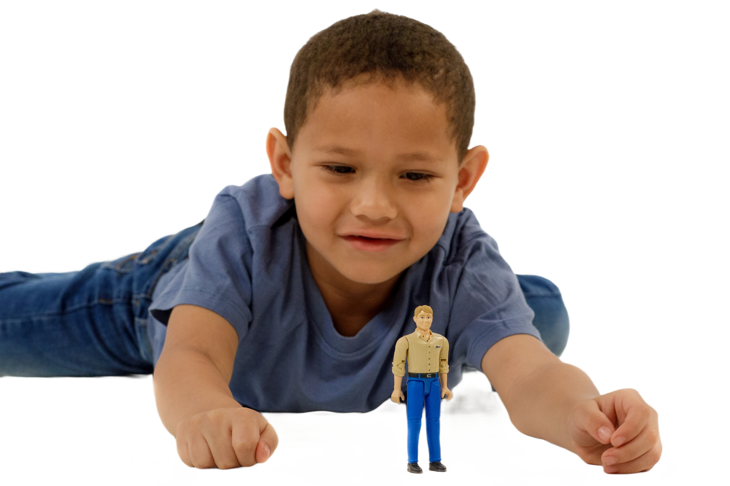 Young boy in blue shirt lying down and playing with a light skin man action figure in blue jeans and tan shirt