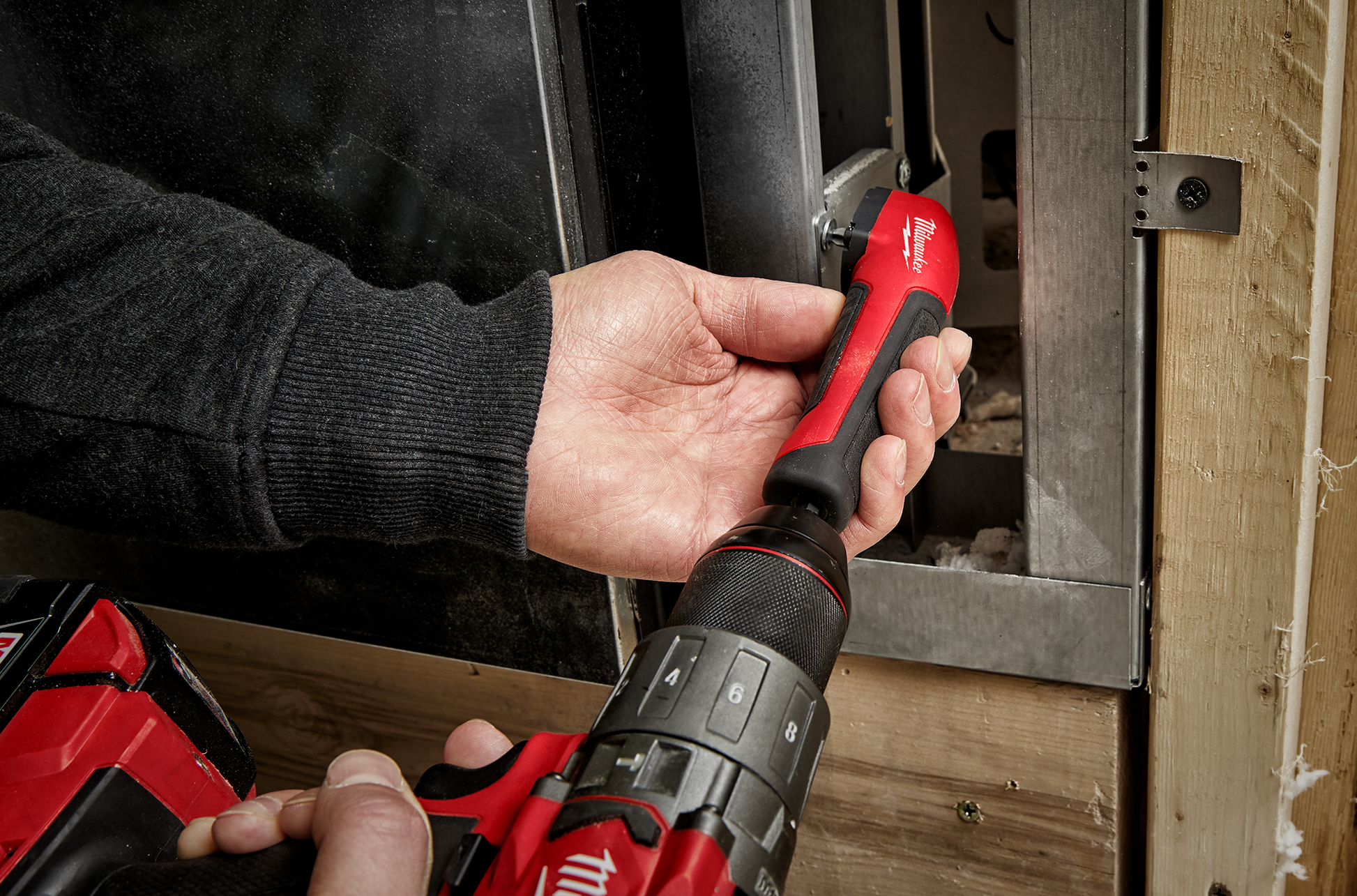 Hand holding Milwaukee SHOCKWAVE™ Impact Right Angle Adapter on drill for woodworking and home improvement tasks