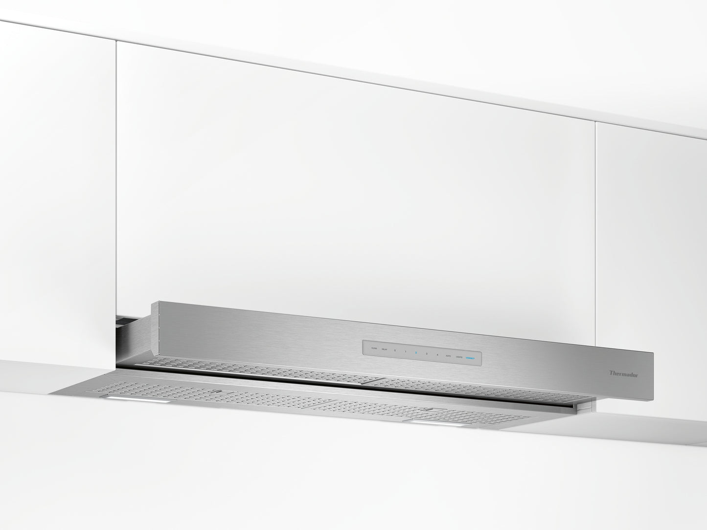 Stainless steel custom insert range hood installed under white cabinetry in modern kitchen setting
