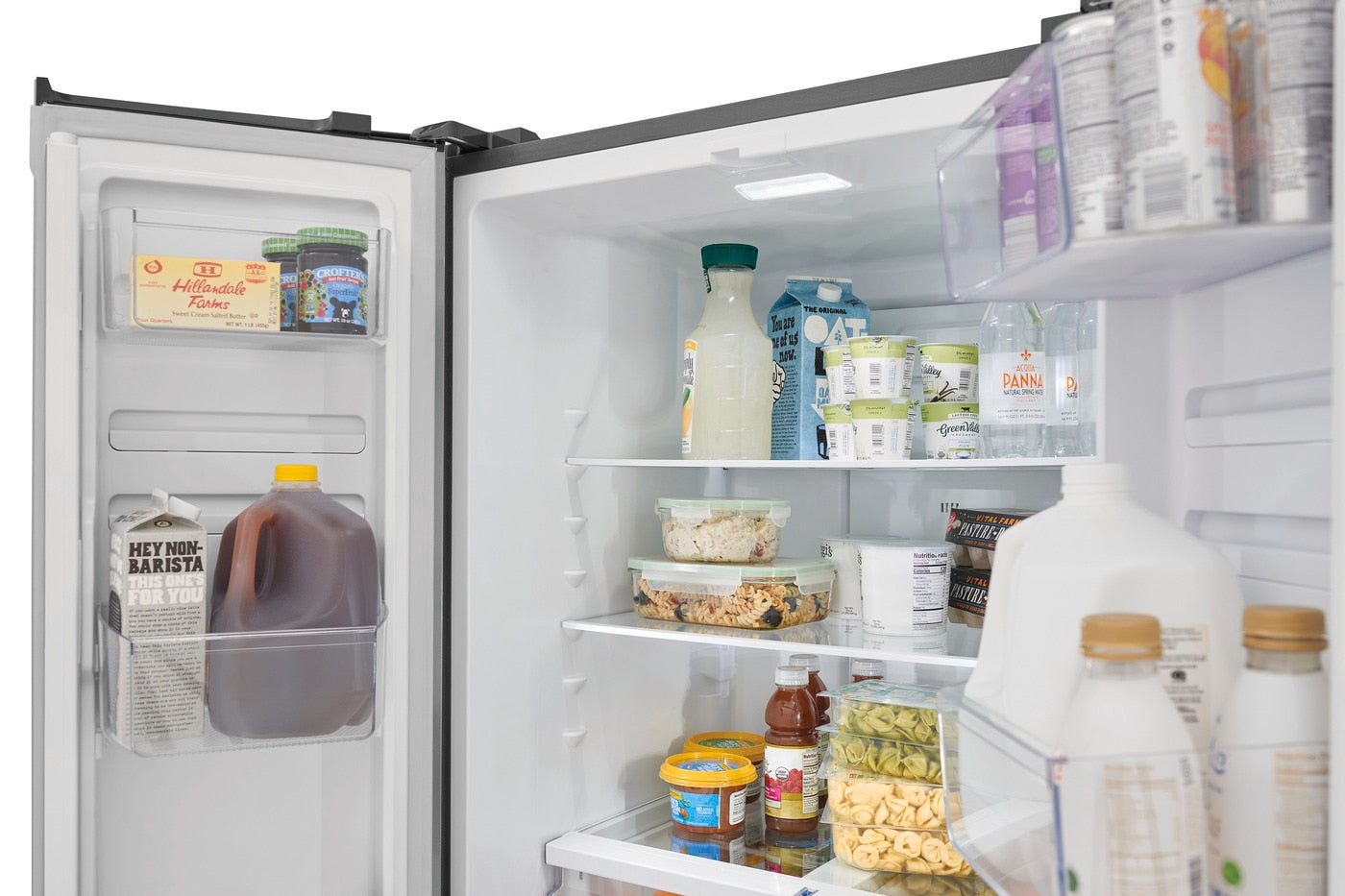 Open stainless steel counter-depth French door refrigerator with organized dairy, beverages, and fresh food in kitchen appliance collection
