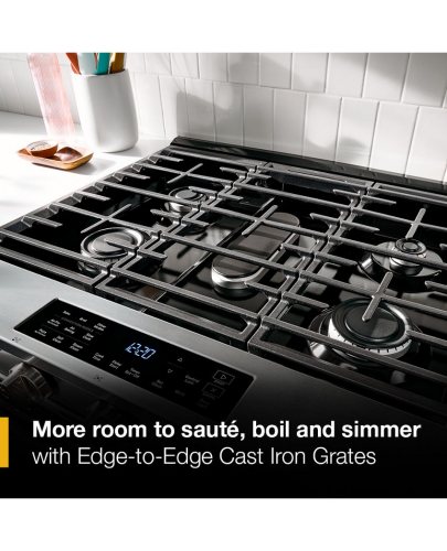 Close-up of black gas cooktop with five burners and Edge-to-Edge cast iron grates in kitchen appliance setting