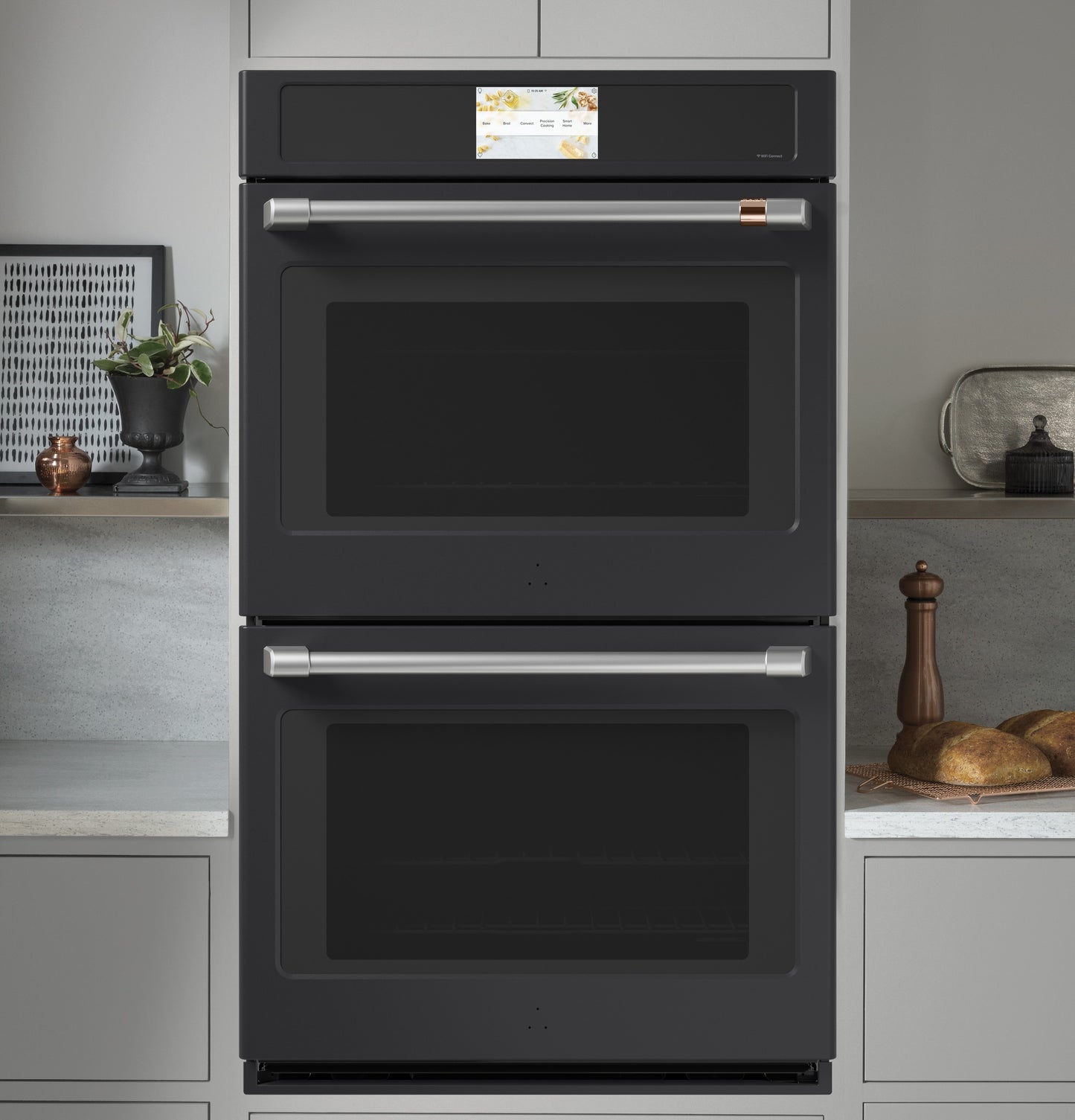Built-in matte black double wall oven with dual stainless steel handles in a modern kitchen appliance setting