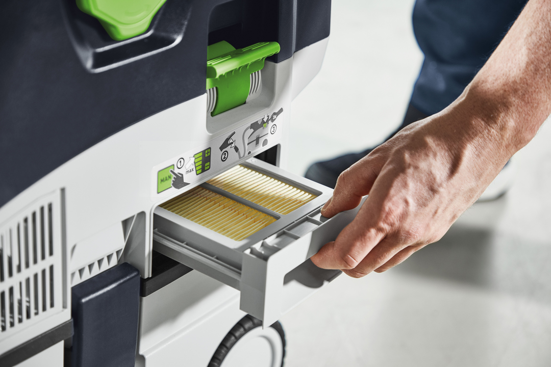 Hand removing HEPA-Plus filter drawer from Festool cordless mobile dust extractor for tools and home improvement tasks