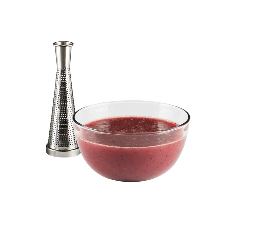 Clear glass bowl with fresh tomato sauce beside a stainless steel electric tomato strainer for kitchen use