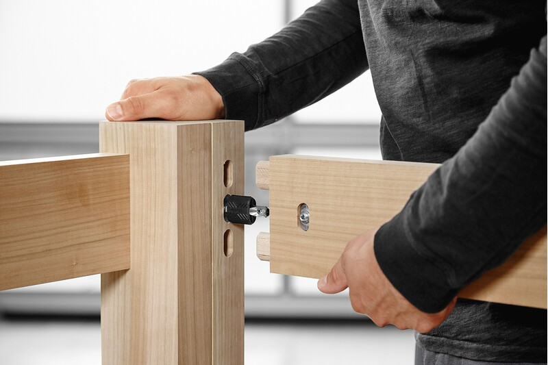 Person assembling wood pieces using a Festool woodworking connector for precise joinery in tool accessories collection