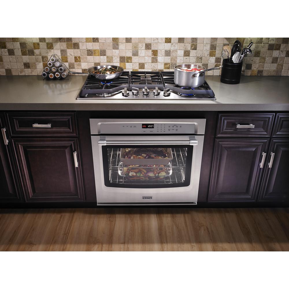 Stainless steel gas cooktop with five burners installed on kitchen countertop, part of home improvement appliances collection