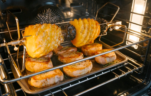 Rotisserie chicken and pineapple cooking inside a stainless steel professional double wall oven from Thermador collection