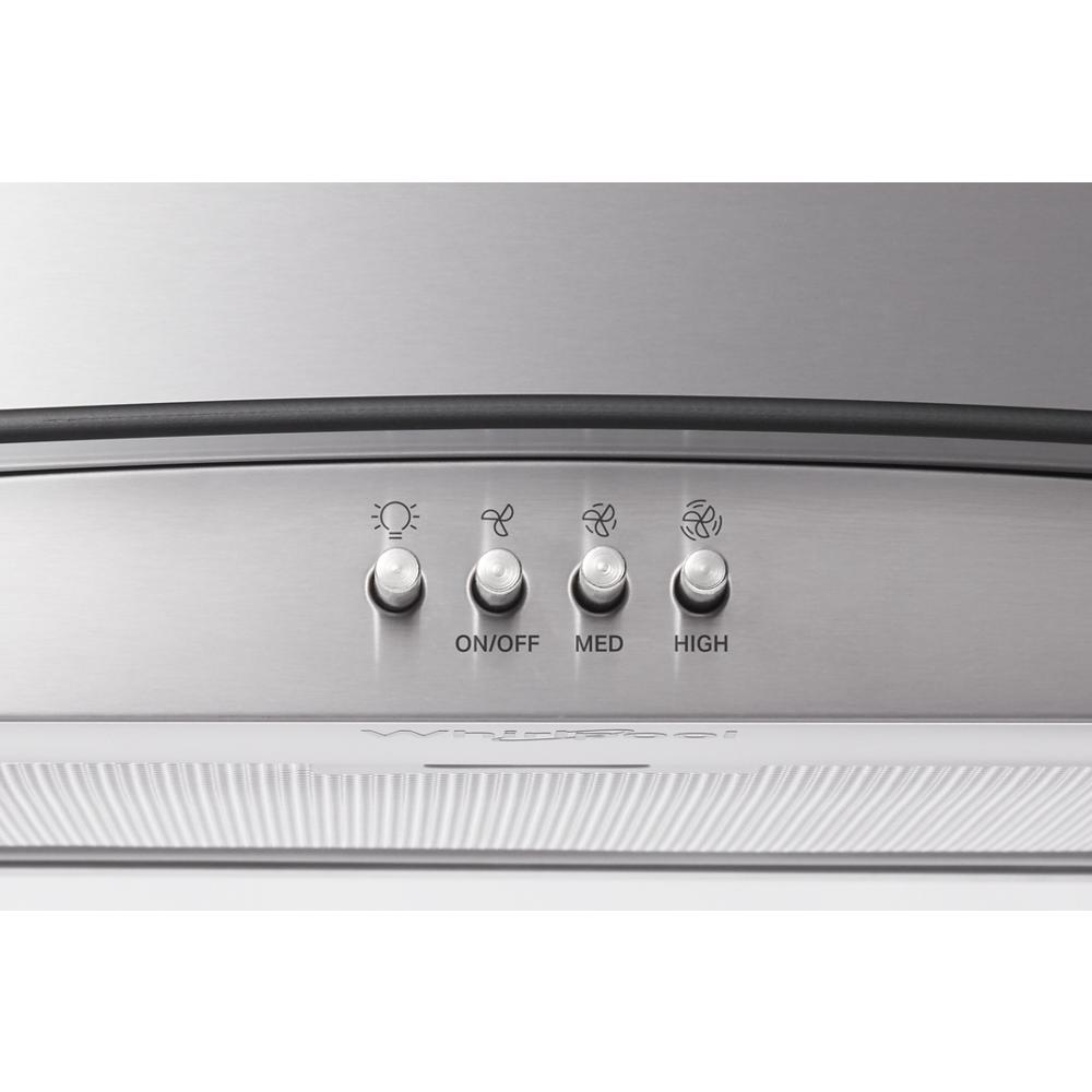 Close-up of stainless steel control panel with light and three-speed fan buttons on kitchen range hood