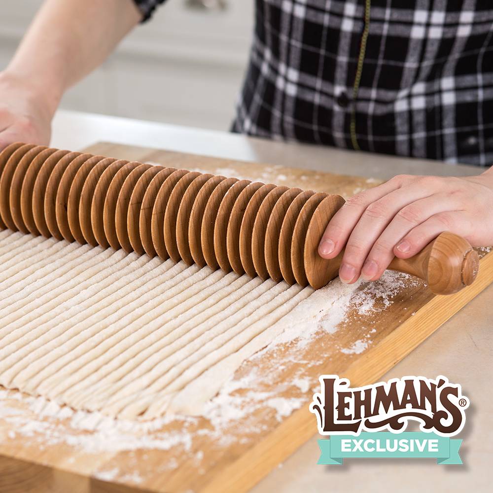 Wooden noodle cutter with evenly spaced discs slicing dough on a floured board for kitchenware collections under $50