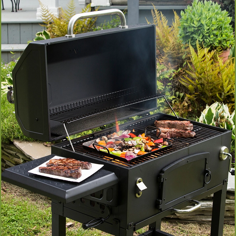 Outdoor charcoal grill with carbon steel grilling pan cooking mixed vegetables and steak in a backyard setting