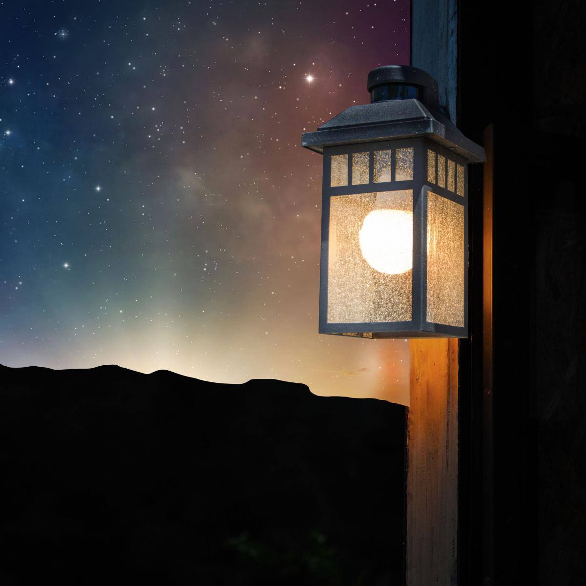 Outdoor wall lantern with glowing light bulb illuminating nighttime sky and stars in home improvement collections