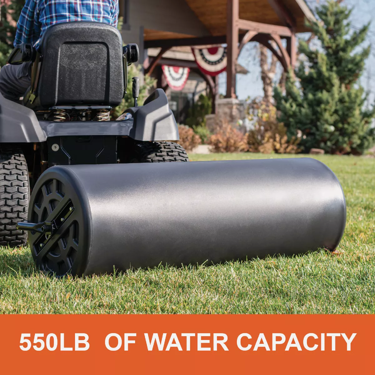 Black polyethylene lawn roller attached to riding mower, used for smoothing grass in home improvement tools collection