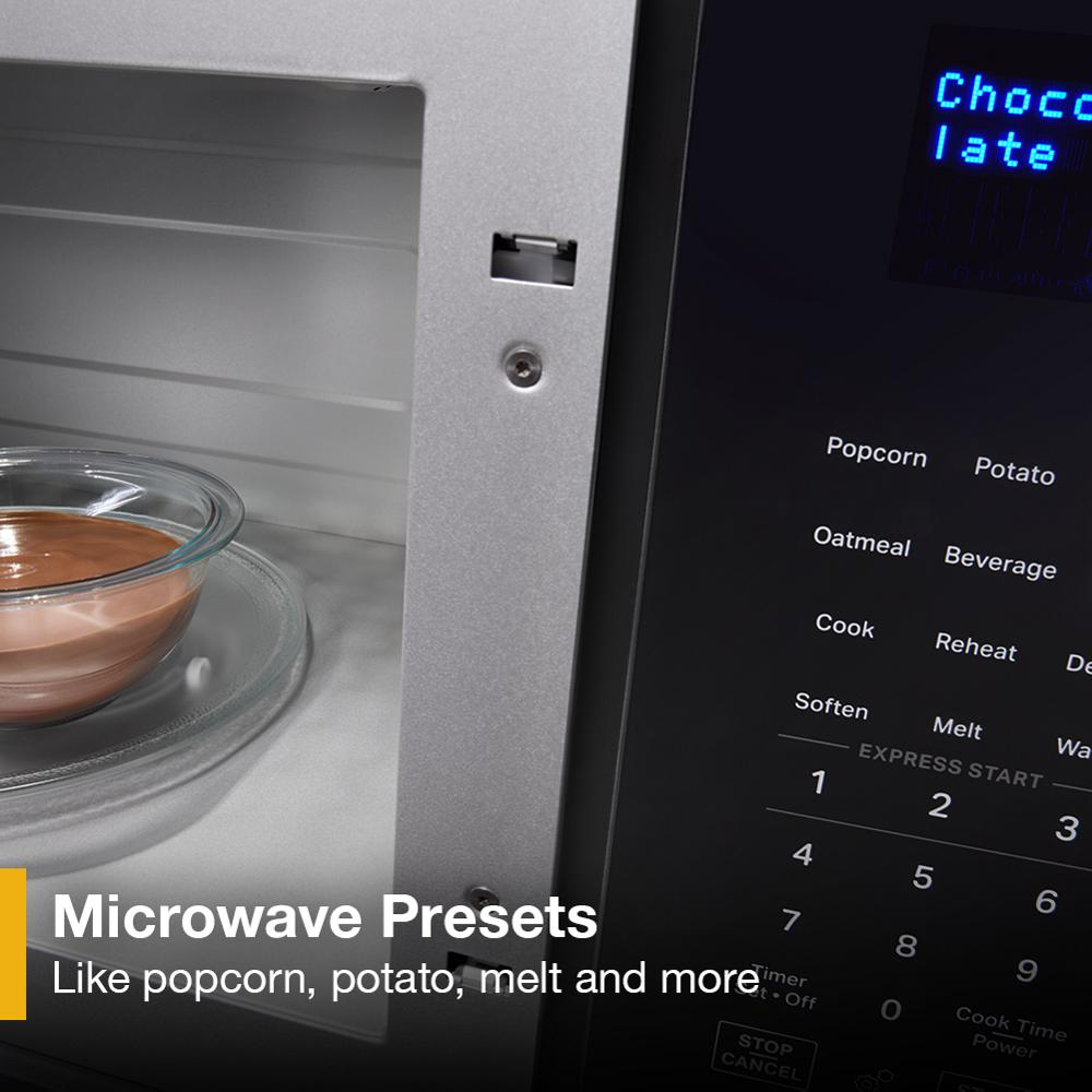 Close-up of microwave interior with glass bowl and control panel showing preset cooking options for popcorn and potato